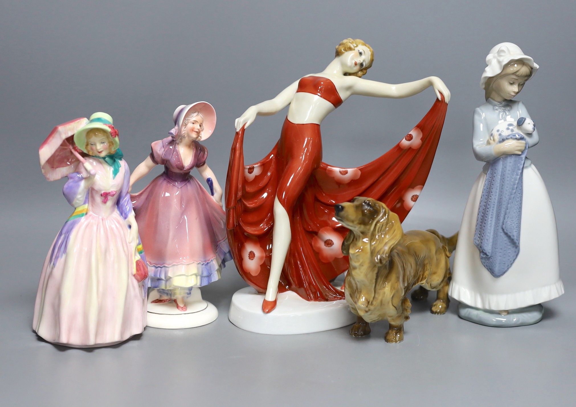 Four mixed figurines and a model of a dog, to include a Royal Doulton figure ‘Miss Demure’ (5)